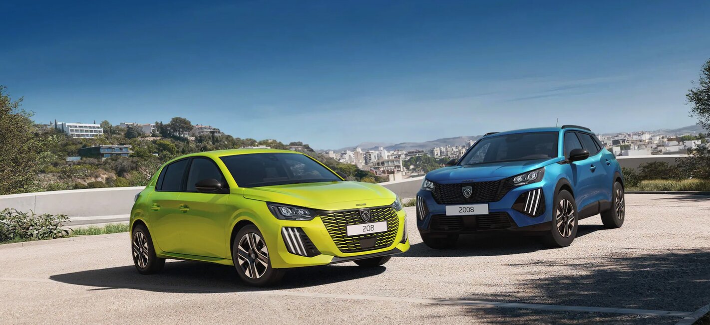 Ein Peugeot 208 und 2008 auf einer Anhöhe mit Stadtpanorama im Hintergrund.